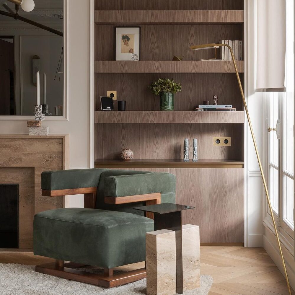home-hero-1 Image d'un meuble sur-mesure imitation bois derrière un fauteuil vert dans une pièce de vie